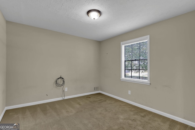 spare room with a textured ceiling and carpet flooring