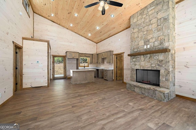 unfurnished living room featuring ceiling fan, high vaulted ceiling, wooden ceiling, wood-type flooring, and a stone fireplace