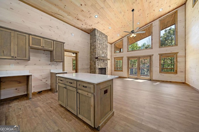 kitchen featuring a center island, ceiling fan, wooden ceiling, high vaulted ceiling, and light hardwood / wood-style flooring