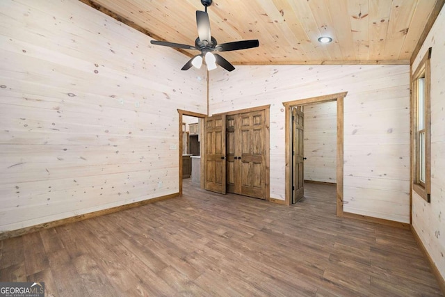 unfurnished bedroom with wood ceiling, ceiling fan, lofted ceiling, wooden walls, and hardwood / wood-style flooring