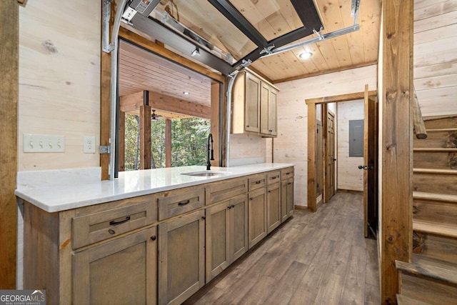 kitchen with wood ceiling, dark wood-type flooring, kitchen peninsula, sink, and wood walls