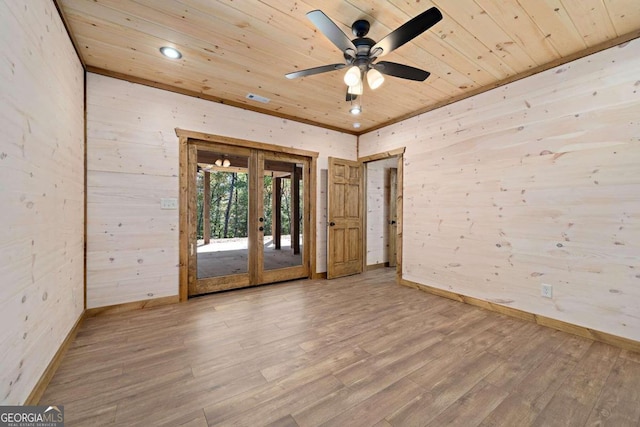 unfurnished room featuring hardwood / wood-style floors, french doors, wood ceiling, and wood walls