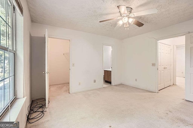 carpeted empty room with a textured ceiling and ceiling fan