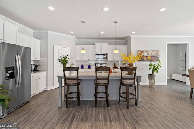 kitchen with stainless steel appliances, a center island with sink, pendant lighting, white cabinetry, and dark hardwood / wood-style flooring