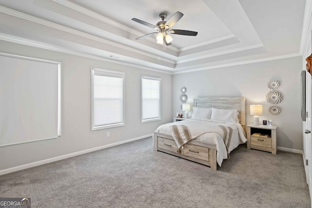 carpeted bedroom with crown molding, a raised ceiling, and ceiling fan