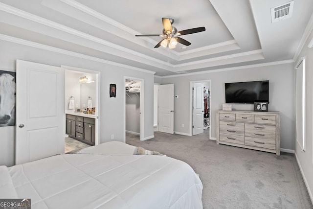 bedroom with ceiling fan, a walk in closet, a closet, and ensuite bath