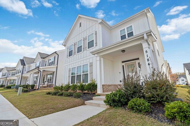 townhome / multi-family property with a front yard and a porch