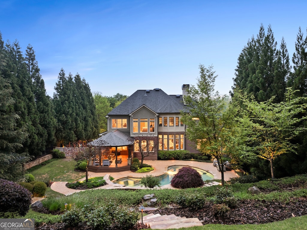 back of property featuring a patio and a hot tub