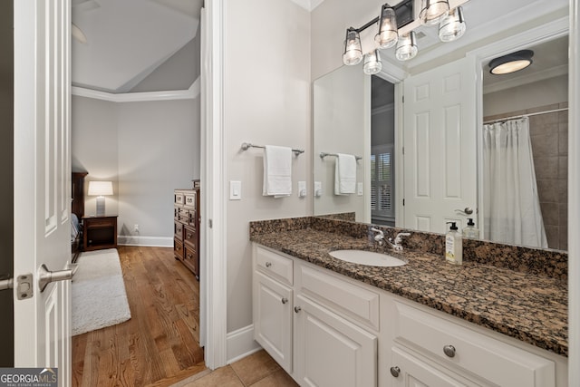 bathroom with vanity, crown molding, and hardwood / wood-style flooring