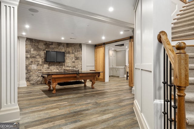 rec room with hardwood / wood-style floors, a barn door, pool table, and decorative columns