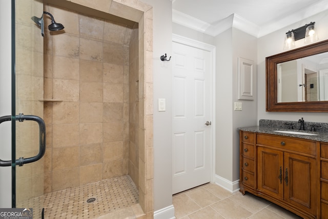 bathroom with a shower with door, vanity, crown molding, and tile patterned floors