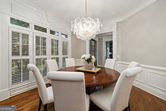 dining room with ornamental molding, an inviting chandelier, and dark hardwood / wood-style flooring