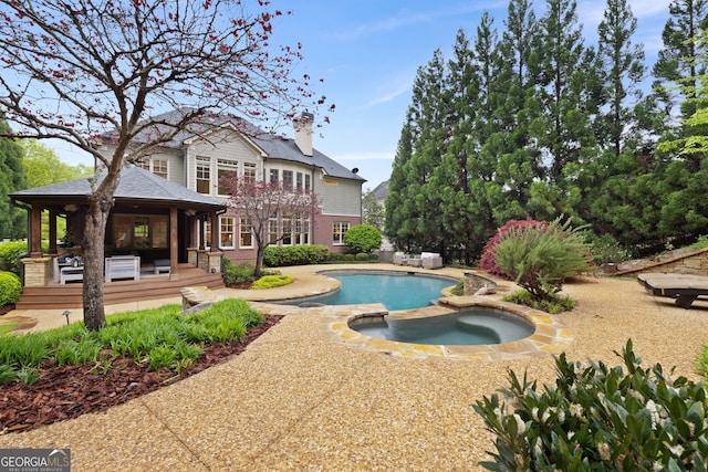 view of swimming pool featuring an in ground hot tub and a patio area