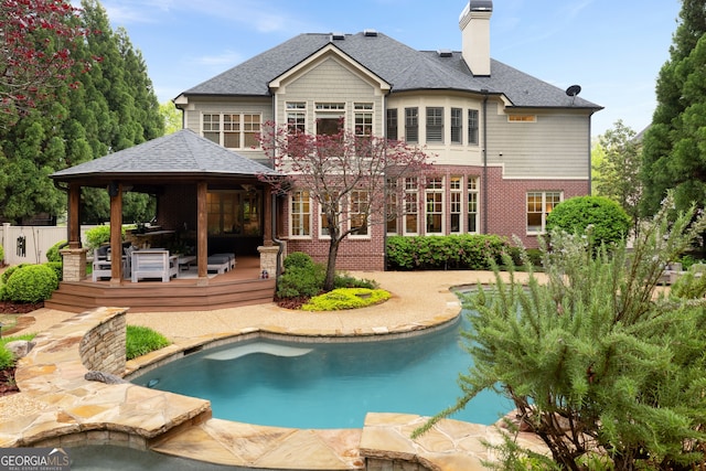 back of property featuring a patio and a swimming pool side deck