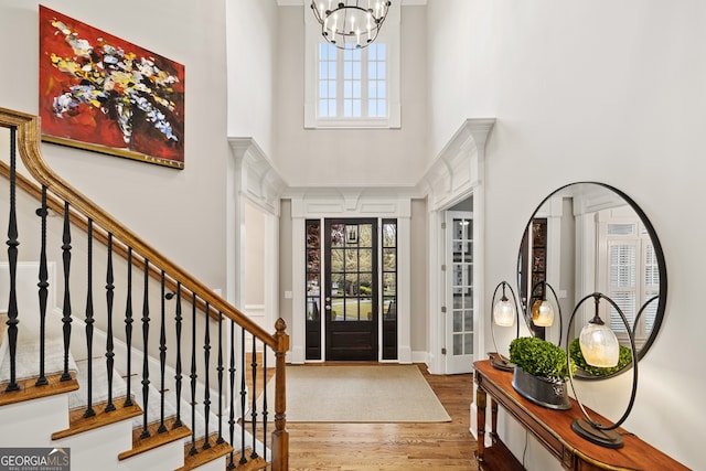 entrance foyer featuring a high ceiling, a notable chandelier, and hardwood / wood-style flooring