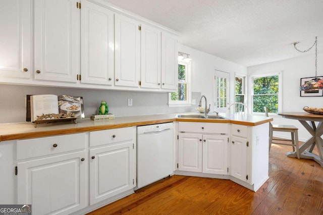 kitchen with sink, white dishwasher, kitchen peninsula, white cabinets, and light hardwood / wood-style flooring