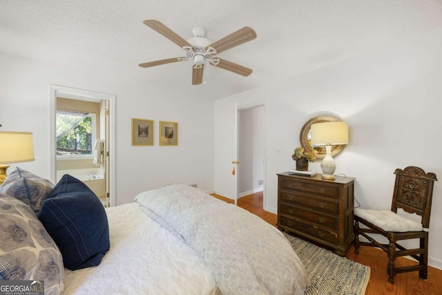 bedroom featuring connected bathroom, a textured ceiling, wood-type flooring, and ceiling fan