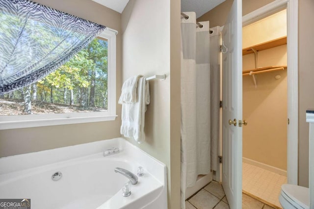 bathroom featuring a wealth of natural light, shower with separate bathtub, and toilet