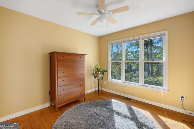 sitting room with hardwood / wood-style flooring and ceiling fan