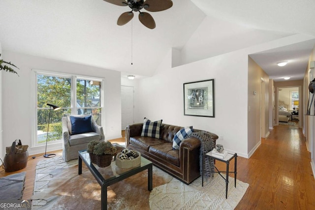 living room with ceiling fan, hardwood / wood-style flooring, and lofted ceiling