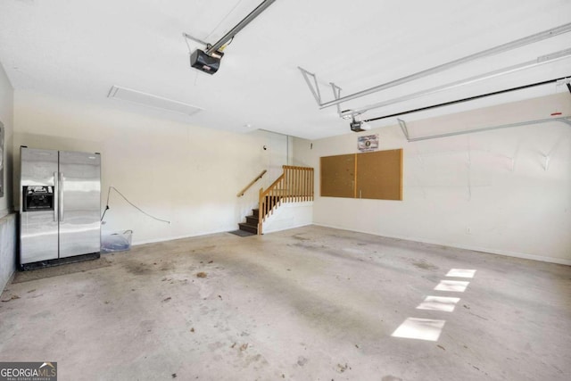 garage featuring stainless steel fridge and a garage door opener