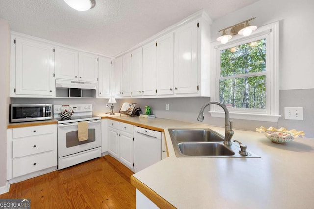 kitchen featuring a textured ceiling, white cabinetry, light hardwood / wood-style floors, sink, and white appliances