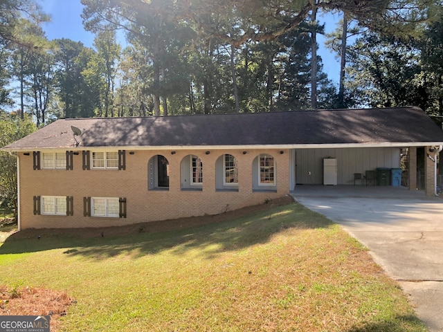 ranch-style home featuring a carport and a front lawn