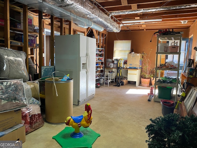 basement with white refrigerator with ice dispenser