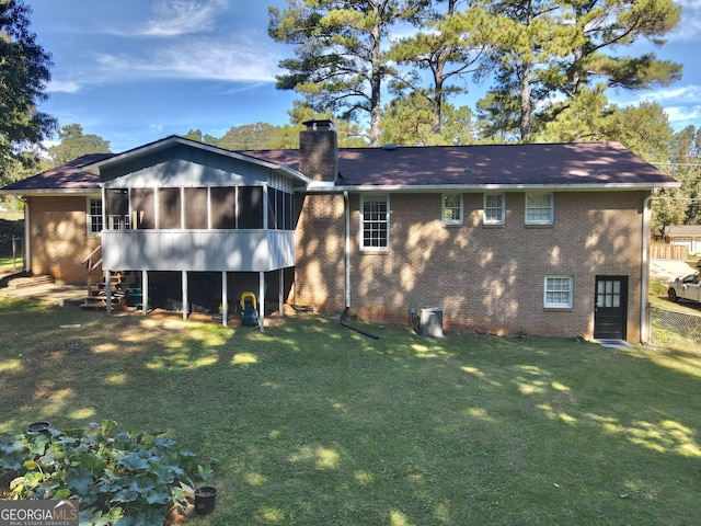 back of property featuring a sunroom and a yard