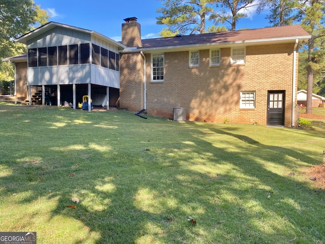 back of property with a sunroom and a yard