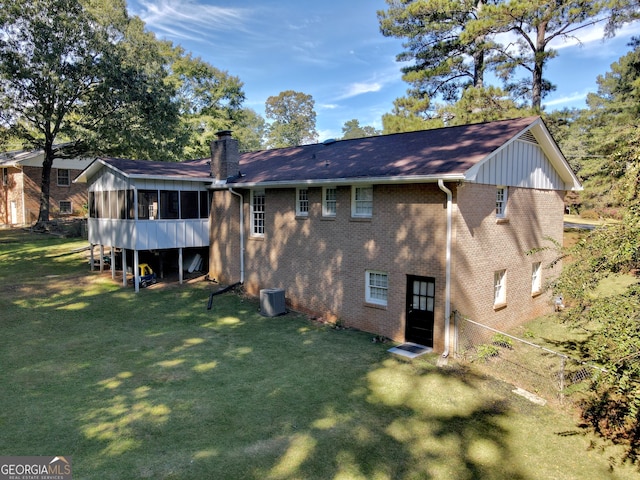 back of house featuring cooling unit, a sunroom, and a yard