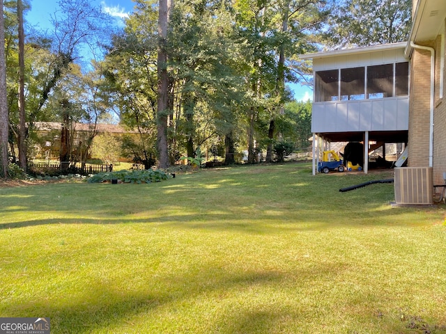 view of yard featuring central AC unit and a sunroom