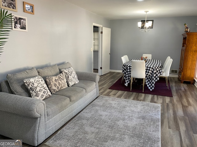 living room with a notable chandelier and dark hardwood / wood-style floors