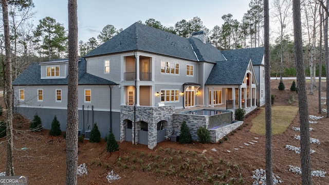 back of house featuring cooling unit, a jacuzzi, and a patio