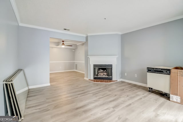 unfurnished living room with crown molding, light hardwood / wood-style floors, and ceiling fan