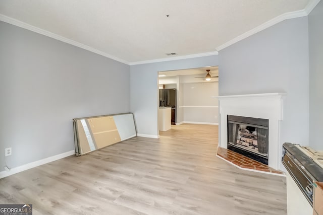 unfurnished living room with crown molding, light hardwood / wood-style floors, and ceiling fan