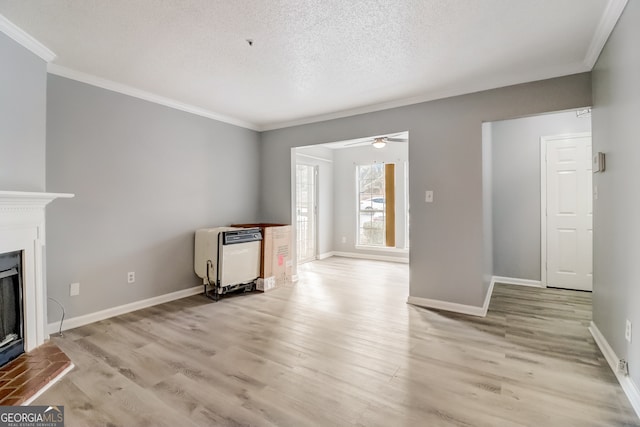 unfurnished living room with ceiling fan, a textured ceiling, heating unit, and light wood-type flooring