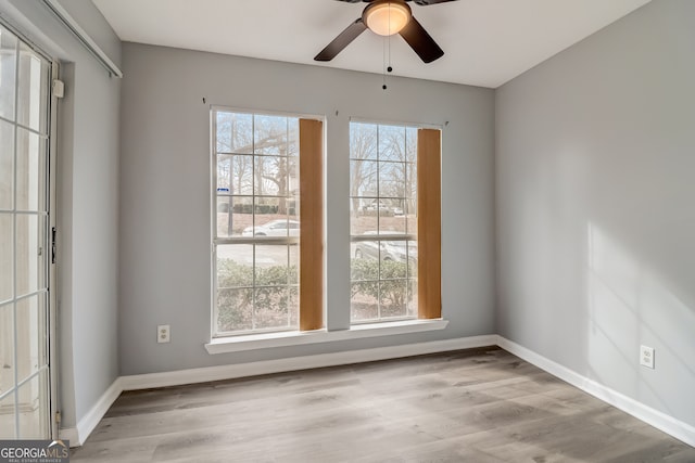 unfurnished room with light hardwood / wood-style flooring, ceiling fan, and a wealth of natural light