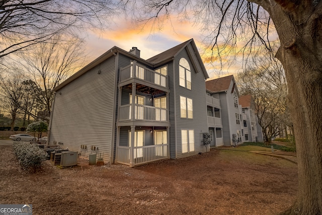 back house at dusk with a balcony