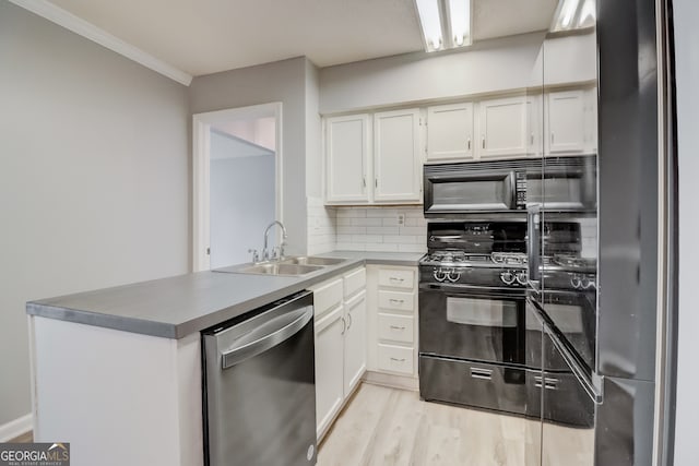 kitchen featuring white cabinetry, tasteful backsplash, black appliances, and sink