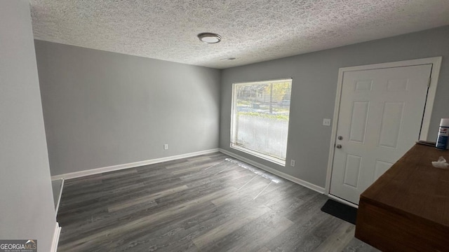 entryway with a textured ceiling and dark wood-type flooring