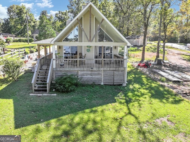 rear view of property featuring a deck and a yard