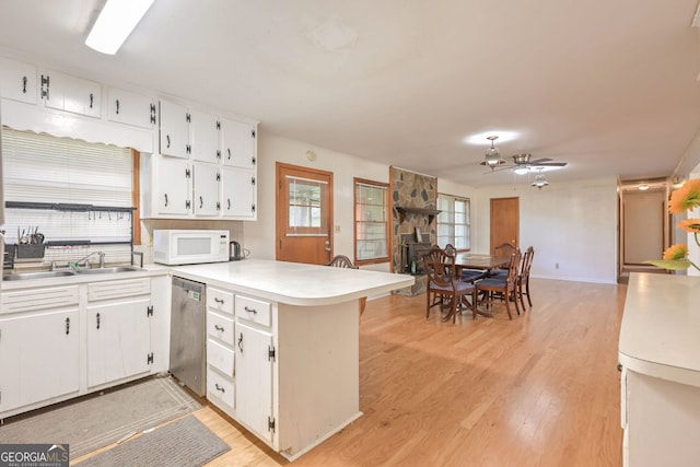 kitchen with light hardwood / wood-style flooring, kitchen peninsula, white cabinetry, and stainless steel dishwasher