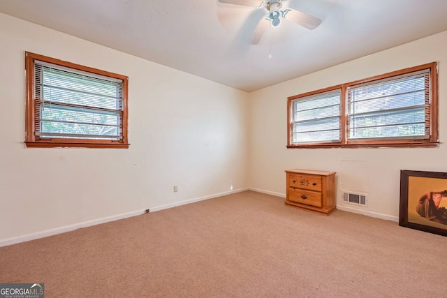 empty room with light colored carpet and ceiling fan