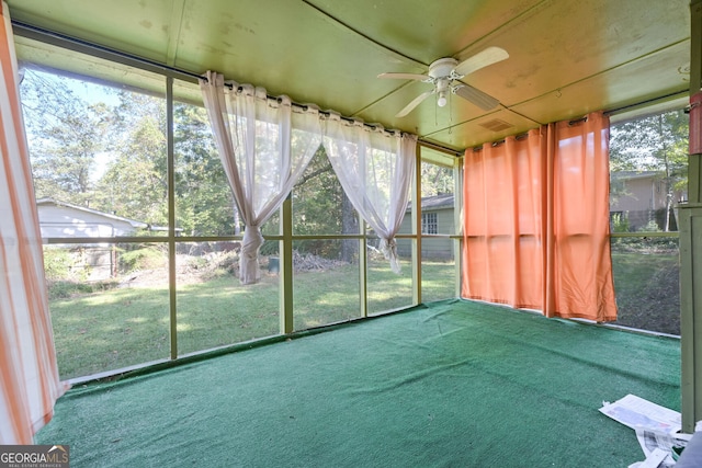 unfurnished sunroom featuring ceiling fan