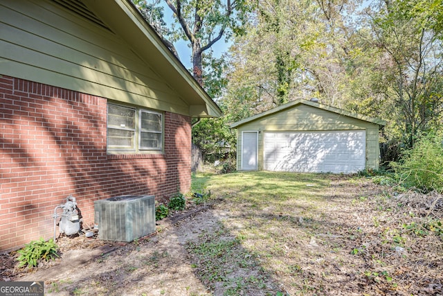 view of yard with central AC, an outbuilding, and a garage