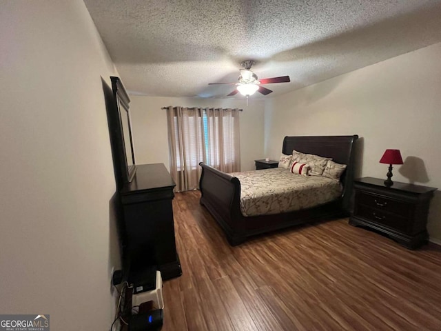 bedroom featuring dark wood-type flooring, a textured ceiling, and ceiling fan