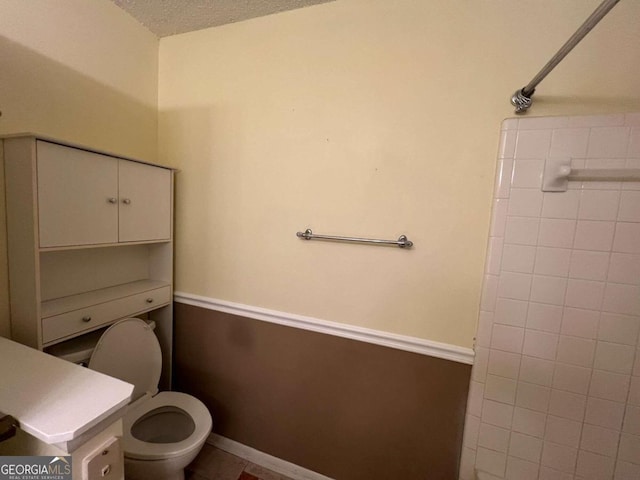 bathroom featuring a textured ceiling and toilet