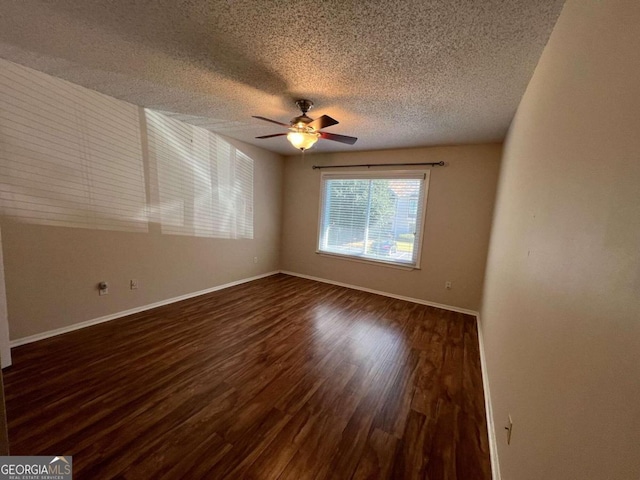 empty room featuring ceiling fan, a textured ceiling, and dark hardwood / wood-style floors