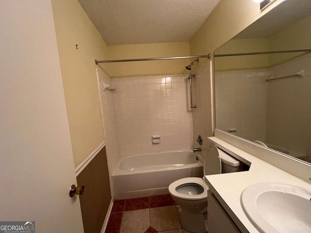 full bathroom with tile patterned floors, toilet, tiled shower / bath, vanity, and a textured ceiling